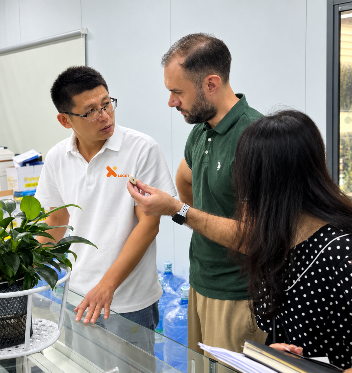 LXCET team discussing a precision component with visiting customers
